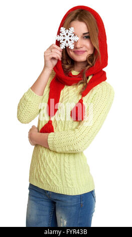 Ragazza vestita in rosso cappello di lana e sciarpa mostrano grande simbolo del fiocco di neve, in posa di studio su sfondo bianco Foto Stock