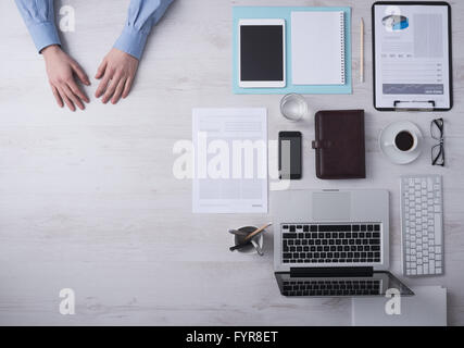 Imprenditore lavora a office desk mani dettaglio con copyspace e vari oggetti sulla destra, vista dall'alto Foto Stock