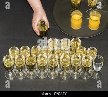 La mano di prendere un bicchiere di vino da tavola visto da sopra al cocktail di benvenuto Foto Stock