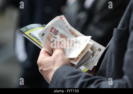 Un uomo detiene un batuffolo di contanti presso il 2016 Grand National presso l'Aintree Racecourse in Liverpool, UK. Foto Stock