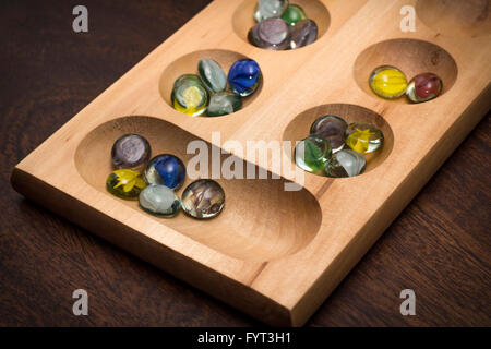 Mancala tradizionale tavolo con pezzi di vetro sul tavolo di legno Foto Stock