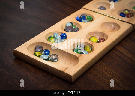 Mancala tradizionale tavolo con pezzi di vetro sul tavolo di legno Foto Stock