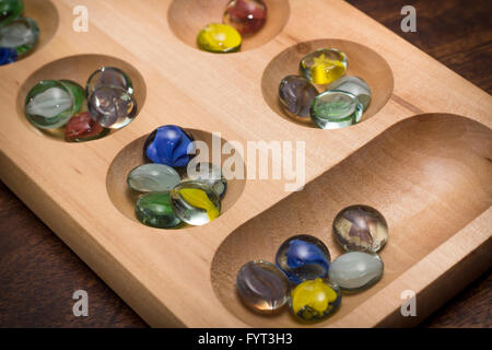 Mancala tradizionale tavolo con pezzi di vetro sul tavolo di legno Foto Stock