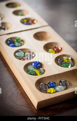 Mancala tradizionale tavolo con pezzi di vetro sul tavolo di legno Foto Stock