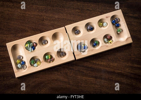 Mancala tradizionale tavolo con pezzi di vetro sul tavolo di legno Foto Stock