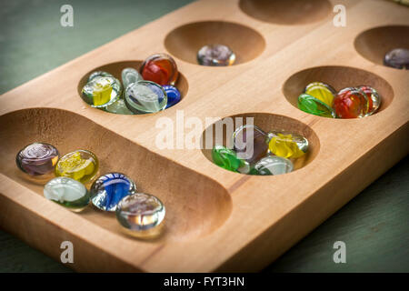 Mancala tradizionale tavolo con pezzi di vetro sul tavolo di legno Foto Stock