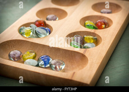 Mancala tradizionale tavolo con pezzi di vetro sul tavolo di legno Foto Stock