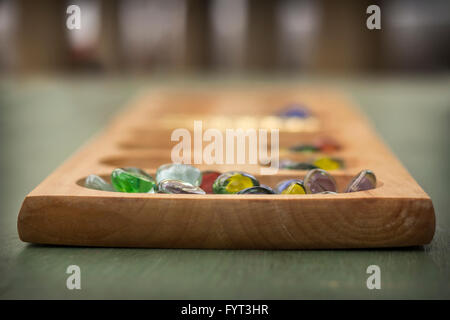 Mancala tradizionale tavolo con pezzi di vetro sul tavolo di legno Foto Stock