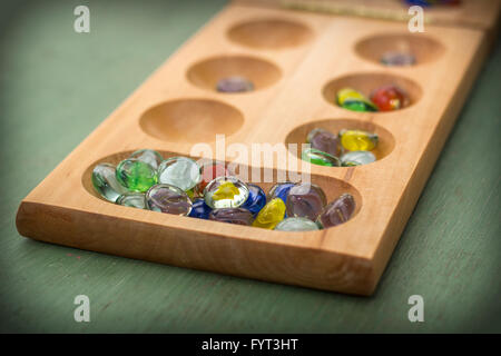 Mancala tradizionale tavolo con pezzi di vetro sul tavolo di legno Foto Stock
