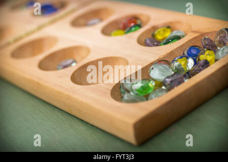 Mancala tradizionale tavolo con pezzi di vetro sul tavolo di legno Foto Stock