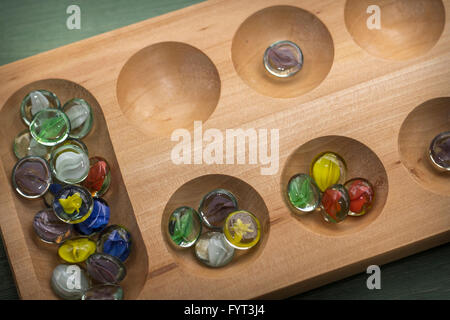 Mancala tradizionale tavolo con pezzi di vetro sul tavolo di legno Foto Stock