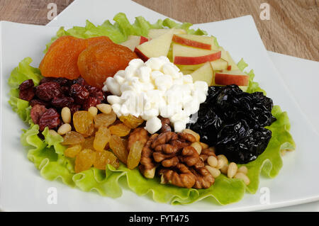 Vitamina insalata con dadi, mele, frutta secca e formaggio in foglie di lattuga Foto Stock