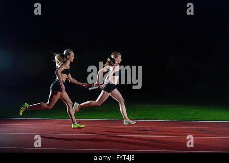 I corridori atletici passando il testimone nella staffetta Foto Stock