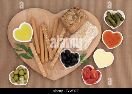 Crudities fresca selezione di snack con bastoncini di pane e panini, mayo e dolce salse piccanti, olive, olio, cetrioli e pomodori. Foto Stock