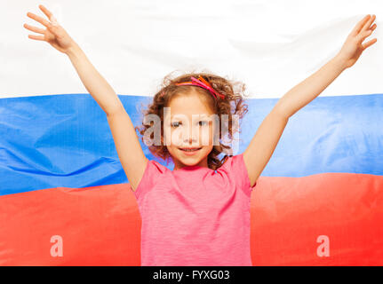 Ragazza alzando le mani in alto, Bandiera della Russia dietro Foto Stock