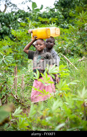 I bambini a trasportare acqua potabile in Uganda Foto Stock