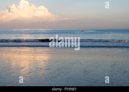 La baia di Jimbaran, Bali, al mattino presto con una solitaria barca da pesca. Foto Stock