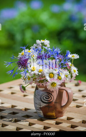 Un mazzo di fiori di campo in un cerchio sul tavolo Foto Stock
