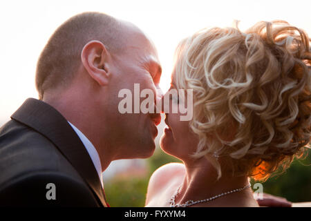 Felice sposa e lo sposo baciare Foto Stock