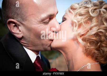 Felice sposa e lo sposo baciare Foto Stock