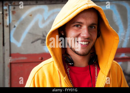 Giovane uomo ritratto su graffiti parete grunge Foto Stock