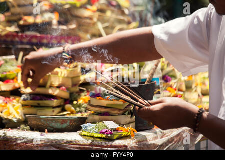 Mani incenso sopra il bello stile Balinese fiorito offerte religiose Foto Stock