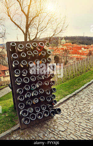 Collezione di vini spumanti di invecchiamento nel rack all'aperto contro la città vecchia di Praga, Repubblica Ceca Foto Stock