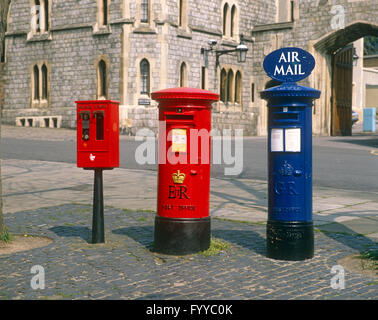 Un set di tre differentemente colorate postboxes, all'esterno. Foto Stock