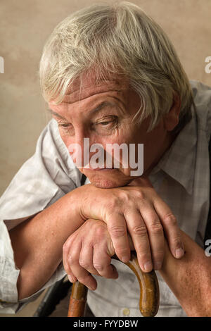 Lonely vecchio in casa di riposo appoggiata sulla sua canna da zucchero Foto Stock