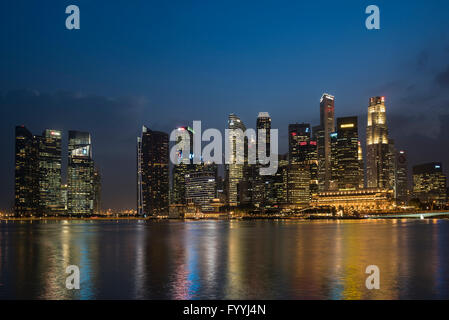 I grattacieli di Singapore il quartiere finanziario al Raffles Place affacciato sulla baia di Marina di sera Foto Stock