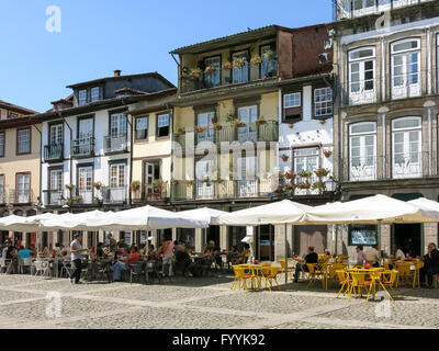 Persone relax sulle caffetterie su Oliveira piazza nel centro storico di Guimaraes, Portogallo Foto Stock