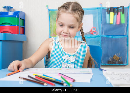 Sconvolto ragazza disegna con matite colorate Foto Stock
