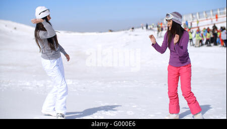 Due giovani donne avente una lotta di neve Foto Stock