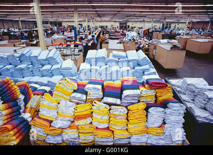 Pile di colorato finito di lenzuola di cotone in un indumento manufacturing facility Foto Stock