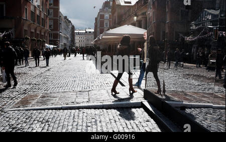 La gente camminare gettando ombre su strade acciottolate intorno al Covent Garden di Londra su bagnato pomeriggio REGNO UNITO Foto Stock