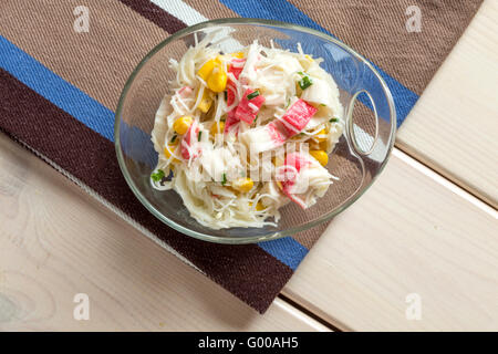 Bastoncini di granchio con spaghetti di riso nel recipiente di vetro sul tessile Foto Stock