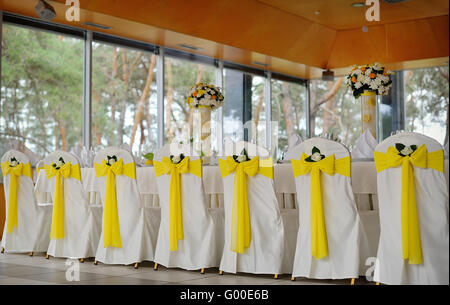 Sedie decorate su un banchetto celebrativo in giallo Foto Stock