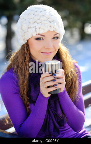 Bella sorridenti inverno donna con la tazza esterna. Ridendo Foto Stock