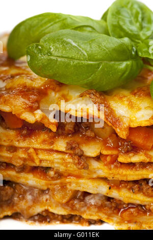 Primo piano di un piatto di lasagne con una foglia di basilico Foto Stock