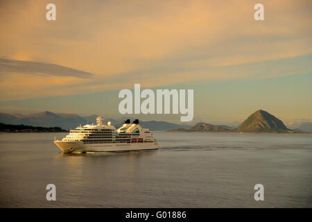 Nave da crociera Seabourn Ricerca vela lontano da Alesund in sera la luce del sole. Foto Stock