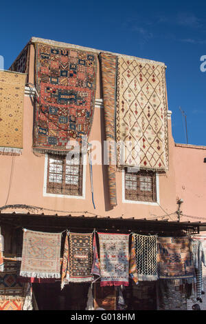 Casa con un negozio di tappeti. Visualizzate i tappeti sospesi dal tetto. Azzurro cielo. Medina di Marrakesh, Marocco. Foto Stock