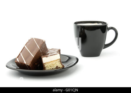 Tre cookie in cioccolato sulla piastra nera e la tazza di caffè isolato su bianco Foto Stock