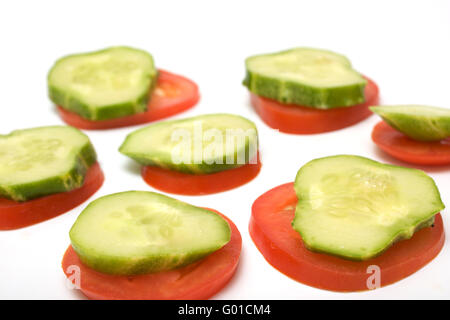 Il cetriolo e pomodoro sono tagliate a fette isolato su bianco. Snack per vegetariani Foto Stock