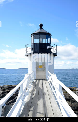 Lunga passerella che conduce al punto di Marshall faro nel Maine. Che circonda la passerella è wate e una costa rocciosa. Foto Stock