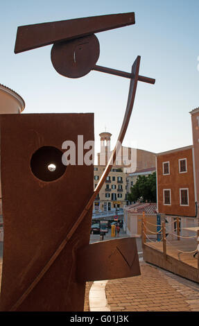 Minorca isole Baleari, Spagna, Europa: Mahon, Plaza del Carmen visti attraverso una scultura di arte pubblica di fronte alla chiesa di Carmen Foto Stock