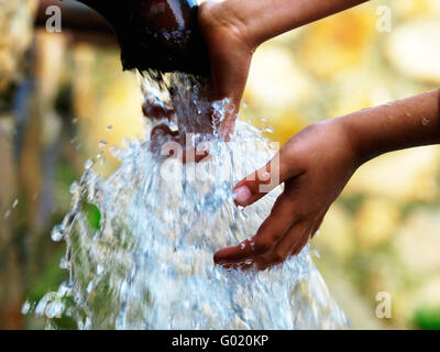 Ragazzo tiene per mano in un flusso di acqua di una molla Foto Stock
