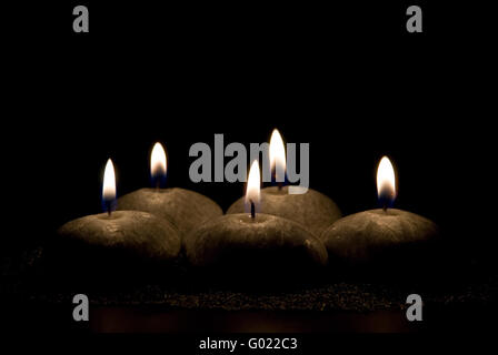 Cinque candele in forma di pietre su sfondo nero Foto Stock
