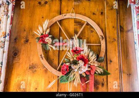 Ruota in legno di un vecchio carro utilizzato come un oggetto decorativo in uno chalet di montagna. Foto Stock