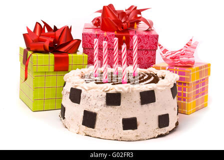 Torta con cinque candele e doni in scatole su sfondo bianco Foto Stock