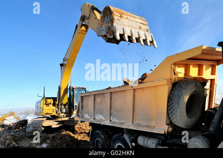 Escavatore caricatore caricamento della terra al corpo di estremità posteriore del cassone ribaltabile Foto Stock